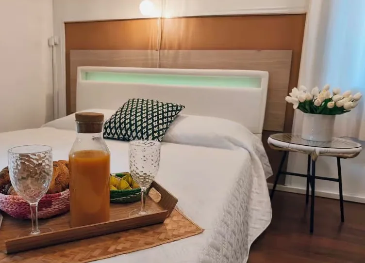 Chambre prête à accueillir : lit fait, plateau de petit-déjeuner et bouquet de tulipes