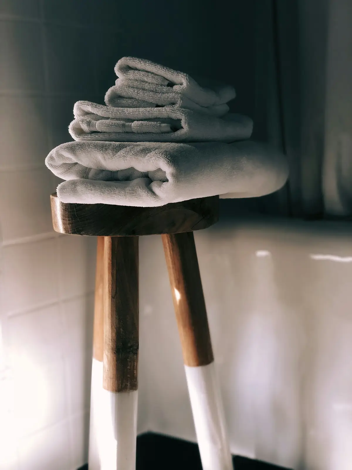 Serviettes blanches pliées sur un tabouret en bois