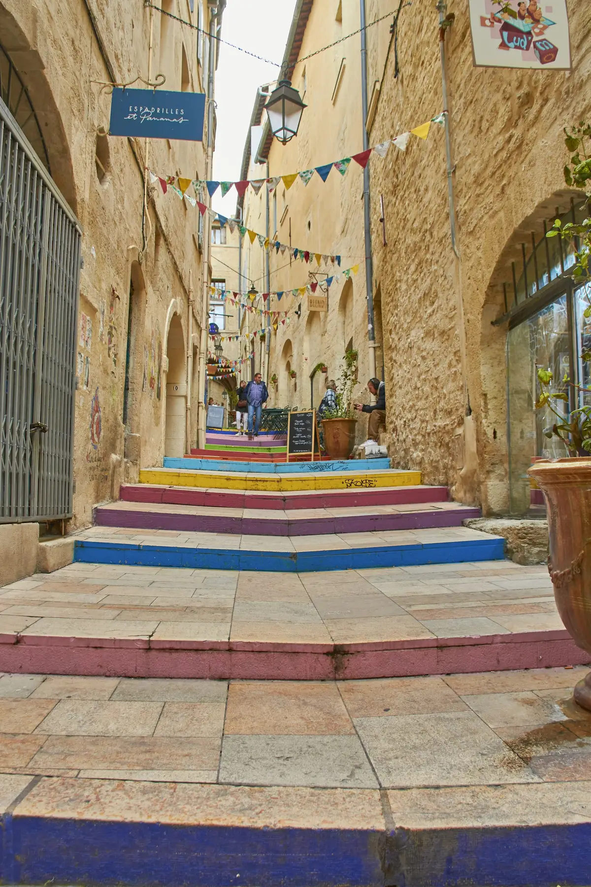 Ruelle en pierre et escalier aux marches colorées dans un centre historique